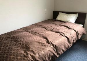 een bed met een paars dekbed in een slaapkamer bij Guesthouse La Cava women's single room / Vacation STAY 21865 in Yokohama
