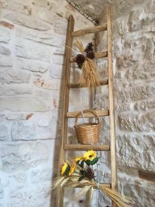 una escalera de madera con una cesta y flores en una mesa en Trullo di Giovannina Casa Vacanza, en Alberobello