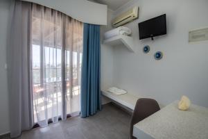 a room with a window with a table and a television at Villa Oasis in Limenaria