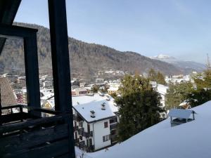 a view of a snowy city from a window at Charming Mountain Penthouse in Aprica