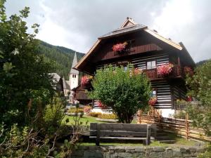 una casa en las montañas con flores en Alte Schule en Bad Kleinkirchheim