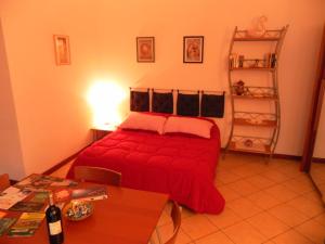 a bedroom with a red bed and a table at Appartamento Madonnina in Trieste