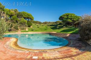 a large swimming pool with a brick pathway around it at L&A Villa with Private heated Pool in Prainha in Alvor