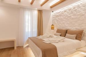 a white bedroom with a large bed with towels on it at Villa Adriana Hotel in Agios Prokopios