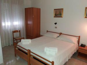 a bedroom with a large bed and a chair at Hotel Europa in Vittoria