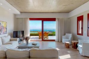 a living room with a couch and a tv at Ocean Villas Complex in Agia Pelagia
