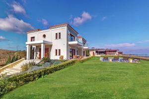 une grande maison blanche avec une grande cour dans l'établissement Ocean Villas Complex, à Agia Pelagia