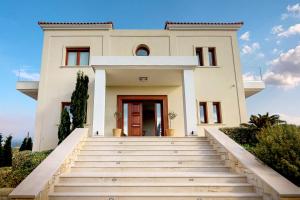 une maison blanche avec des escaliers en face de celle-ci dans l'établissement Ocean Villas Complex, à Agia Pelagia