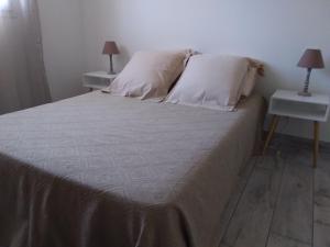 uma cama com duas almofadas e duas mesas com candeeiros em 10 Casa scaledda em Porto-Vecchio