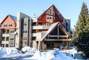 un gran edificio con nieve delante en Lake Placid Lodge by Whiski Jack, en Whistler