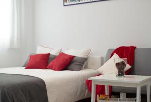 - un salon avec un canapé et des oreillers rouges et blancs dans l'établissement Apartamentos Océanos, à Malaga