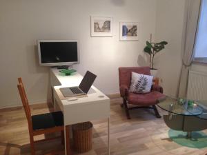 a living room with a desk with a laptop and a tv at Haus Bergstrasse in Stolberg