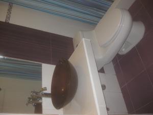 a bathroom with a toilet with a black lid at Hostal Camiluz in Nazca