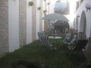 a table and chairs with an umbrella on a patio at Hostal Camiluz in Nazca