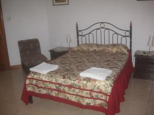 a bedroom with a large bed and a chair at Hostal Camiluz in Nazca