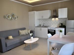 a living room and kitchen with a couch and a table at Jolen House in Skala Kallirachis