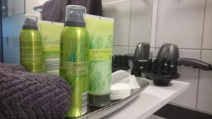 two green bottles sitting on a shelf in a bathroom at K82 studio HOTEL relax&work in Kirchentellinsfurt