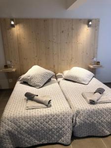 two beds with towels and napkins on top of them at Les Chambres du Moulin a Huile in Vaison-la-Romaine