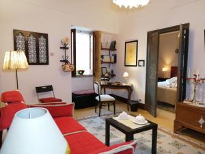 a living room with a red couch and a table at AL-ZABUT in Sambuca di Sicilia