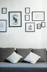 Pokój z kanapą i oprawionymi obrazami na ścianie w obiekcie Cozy studio Campo de Fiori w Rzymie