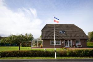 a house with a flag in front of it at Haus Junior in Hohwacht