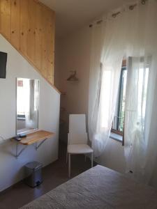 1 dormitorio con cama, silla y espejo en Il lago del Mugello B&B en Barberino di Mugello