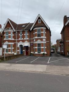 um edifício de tijolos com um parque de estacionamento em frente em Rivendell Guest House em Southampton