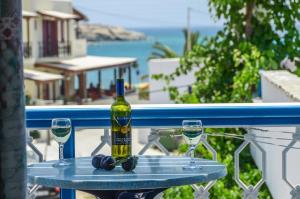 a bottle of wine and two glasses on a table at Polemis Studios & Apartments in Agia Anna Naxos