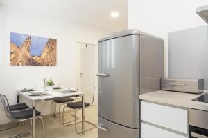 a kitchen with a refrigerator and a table with chairs at Holiday Home Aspalathos in Split