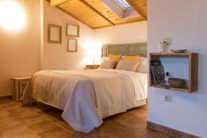 een slaapkamer met een groot wit bed met gele kussens bij La Buhardilla de Huecar in Cuenca