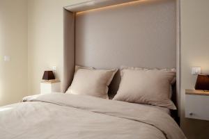 a bedroom with a large bed with white sheets and pillows at LunaRo in Zagreb