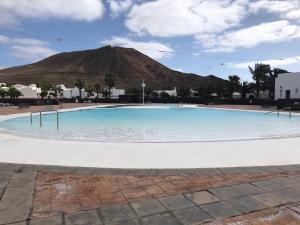 Una gran piscina con una montaña al fondo. en casa Valentina, en Playa Blanca