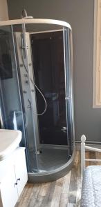 a shower with a glass door in a bathroom at La chambre des cht'is in Vayrac
