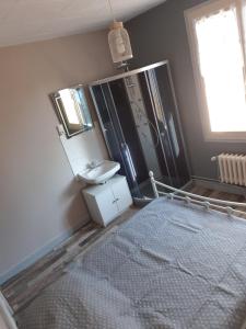 een badkamer met een bed, een wastafel en een spiegel bij La chambre des cht'is in Vayrac