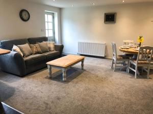 a living room with a couch and a table at Harepath Farm Cottages 1 in Exeter
