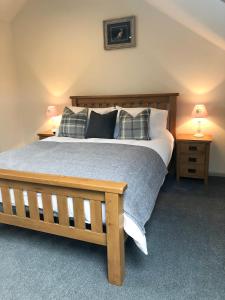 a bedroom with a large bed and two night stands at Harepath Farm Cottages 1 in Exeter