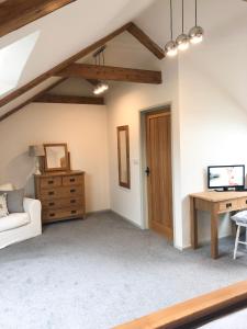 a living room with a white couch and a desk at Harepath Farm Cottages 1 in Exeter