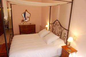 a bedroom with a four poster bed with a mirror at La Pivoine in Sarlat-la-Canéda