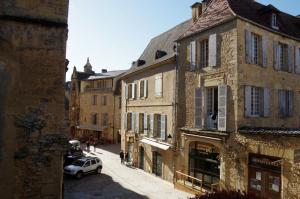 a view of a street with buildings and a car at La Pivoine in Sarlat-la-Canéda