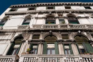 a tall white building with windows and a balcony at Rousseau's Apartment in Venice