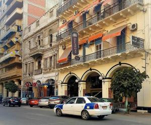 Ein weißes Auto parkte vor einem Gebäude in der Unterkunft De La Poste in Port Said
