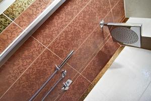 a shower in a bathroom with brown tiles at Strada Giulia 16 in Bolgheri