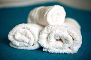 eine Rolle weiße Handtücher auf einem Bett in der Unterkunft Pousada Bela Vista in Conceição da Ibitipoca