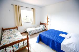 ein Schlafzimmer mit zwei Betten und einem Fenster in der Unterkunft Pousada Bela Vista in Conceição da Ibitipoca