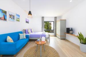 sala de estar con sofá azul y mesa en MayMay Da Lat Apartments, en Da Lat