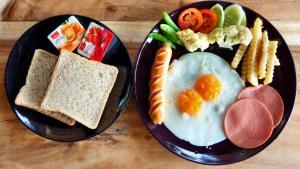 two black plates of breakfast food with eggs and toast at Khunyuam Resort in Ban Khun Yuam