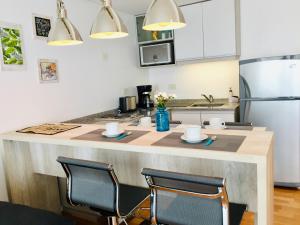 een keuken met een groot aanrecht met 2 stoelen bij Palermo Trendy Studio in Buenos Aires