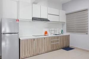 una cucina con armadi bianchi e frigorifero in acciaio inossidabile di H2H - Win de Love Majestic Ipoh a Ipoh