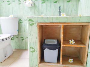 a bathroom with a sink and a toilet and a trash can at Asih Homestay in Pemuteran