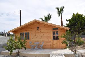 a cabin with chairs and a table in front of it at Cyprus Glamping Park in Ayios Theodhoros